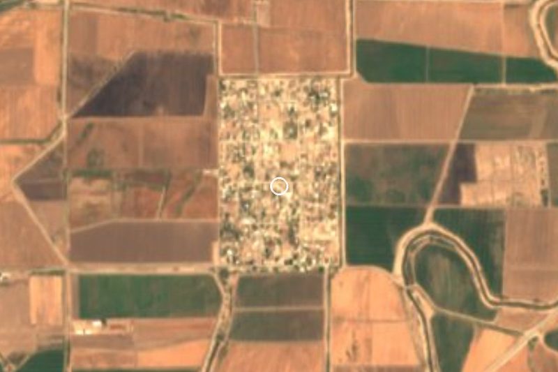 Vista satelital del Ejido Cucapah Indígena, su cuadro de calles entre los campos del valle de Mexicali (el círculo marca el centro), Baja California