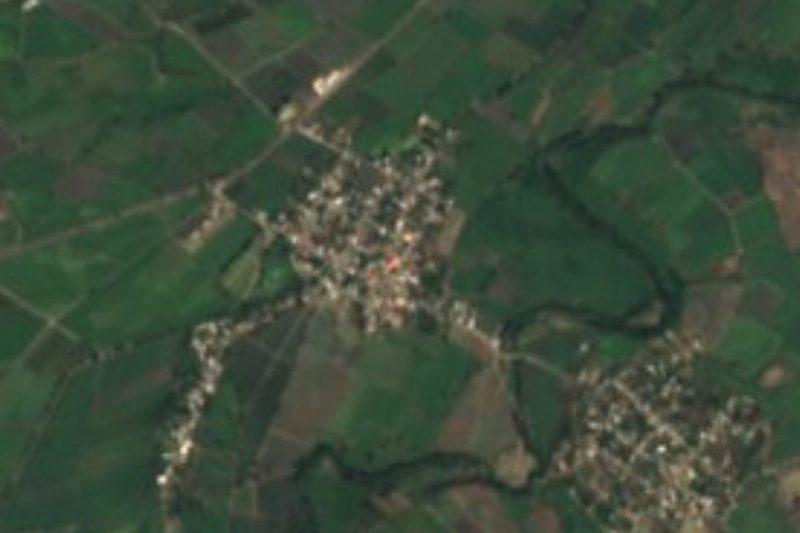 Vista satelital de Ahuehuetzingo, una cuadrícula compacta de casas entre campos verdes al suroeste de Chietla, Puebla
