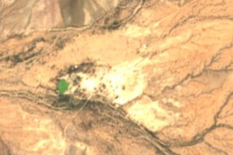 Vista satelital de Quitovac, Sonora: la mancha verde de la laguna alimentada por el manantial y las pocas casas sobre un llano desértico cruzado por arroyos secos