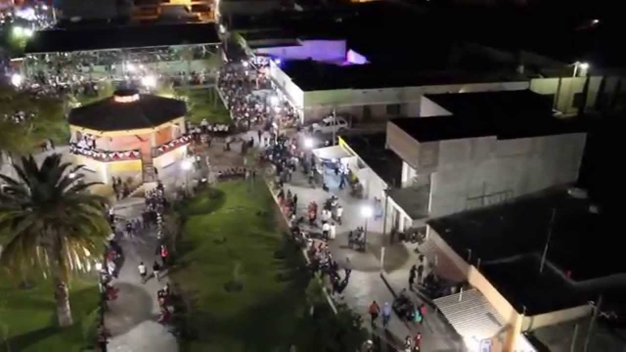 Vista aérea nocturna de la plaza central de Tlahualilo de Zaragoza, con el kiosco iluminado y gente en los andadores, Durango