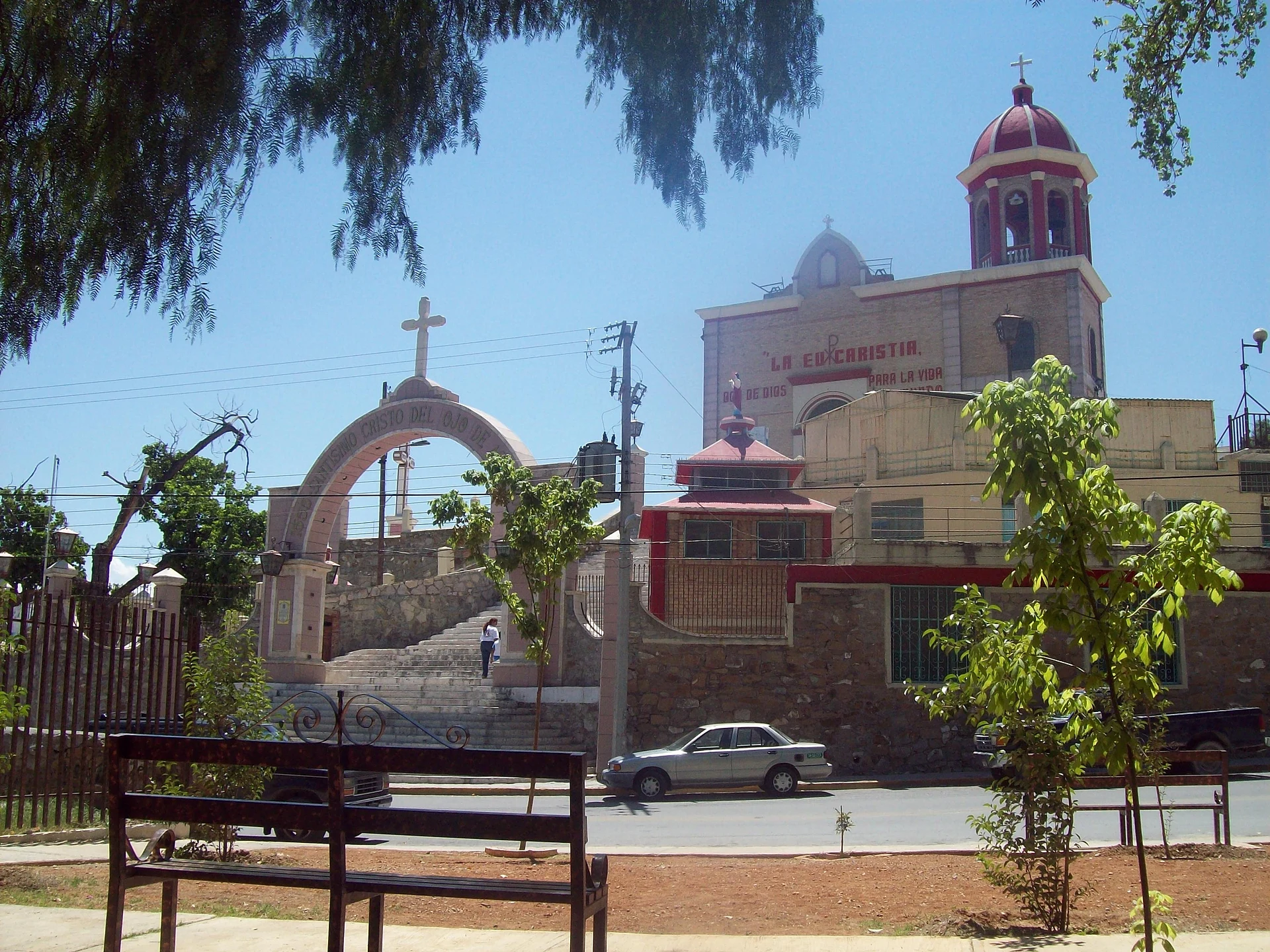 La escalinata y el arco del templo del Santísimo Cristo del Ojo de Agua, en Saltillo, con su campanario de cúpula, vistos desde una plaza, Coahuila