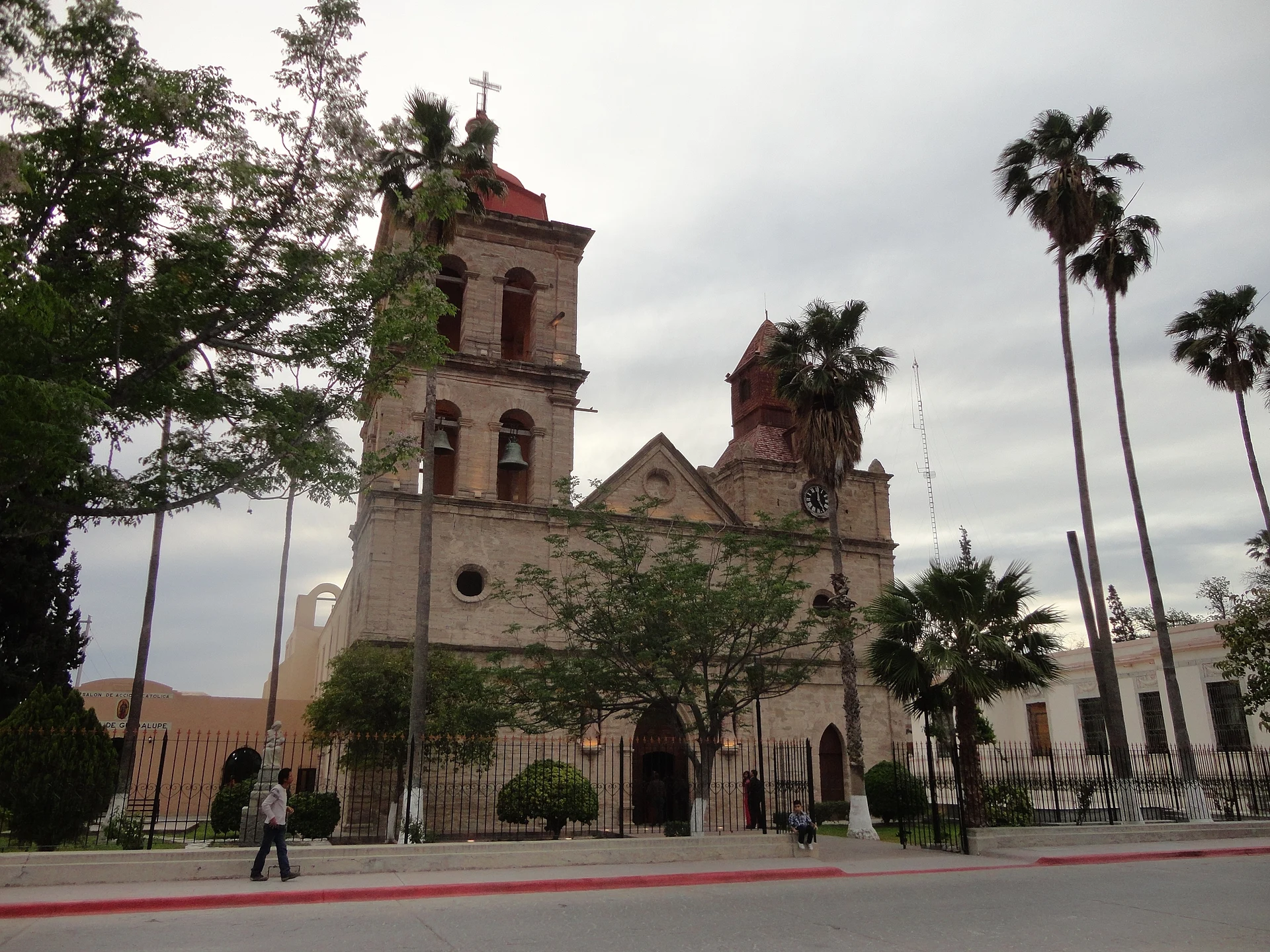 Torres gemelas de piedra de la Parroquia de San José en la plaza con palmeras de Cuatro Ciénegas, Cuatrociénegas, Coahuila