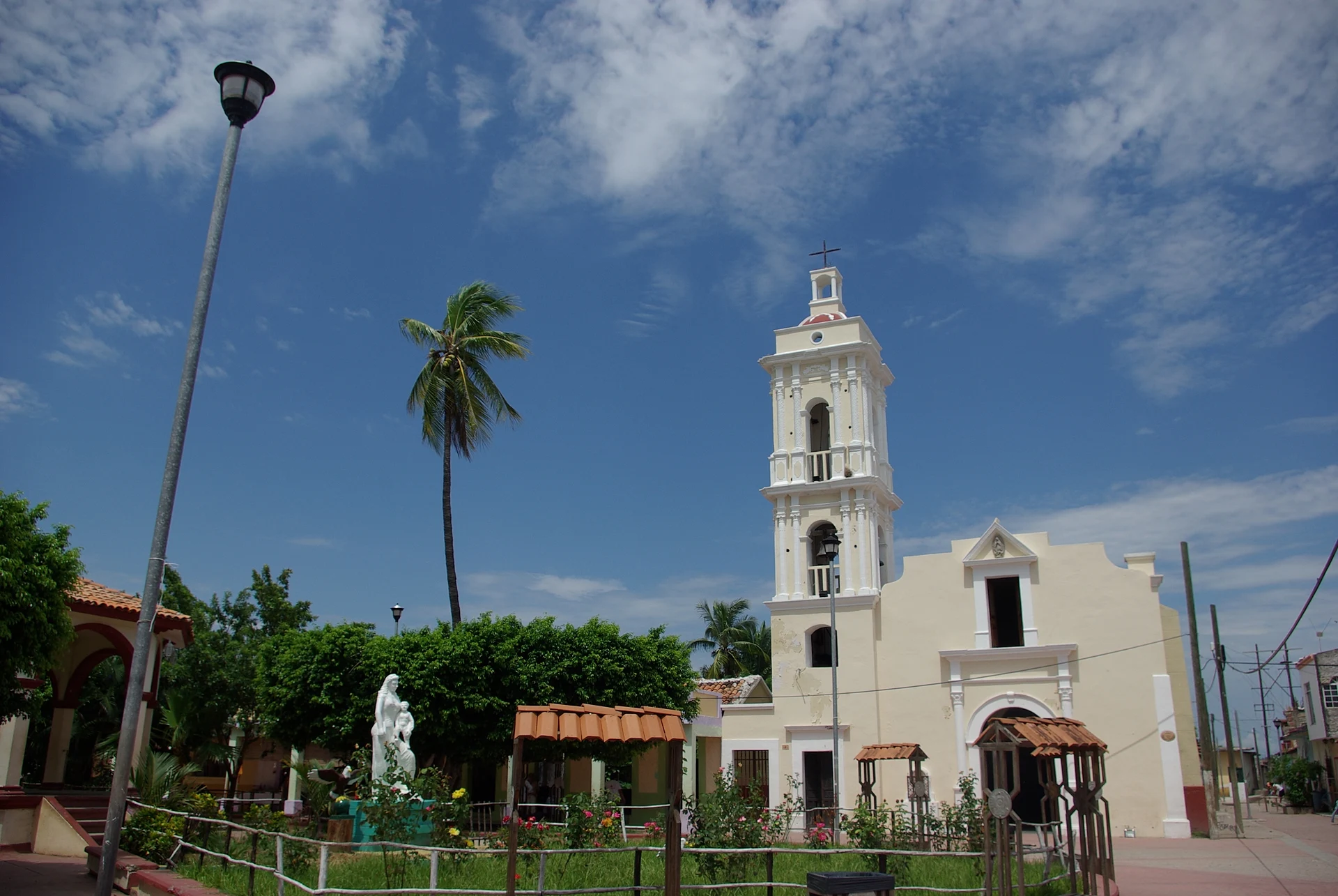 Torre blanca de la iglesia y palmeras en la plaza de Mexcaltitán, Nayarit