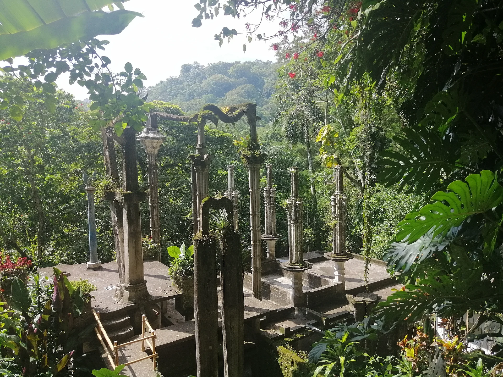Altas columnas y arcos de concreto entre plantas tropicales en el jardín surrealista de Edward James en Las Pozas, San Luis Potosí