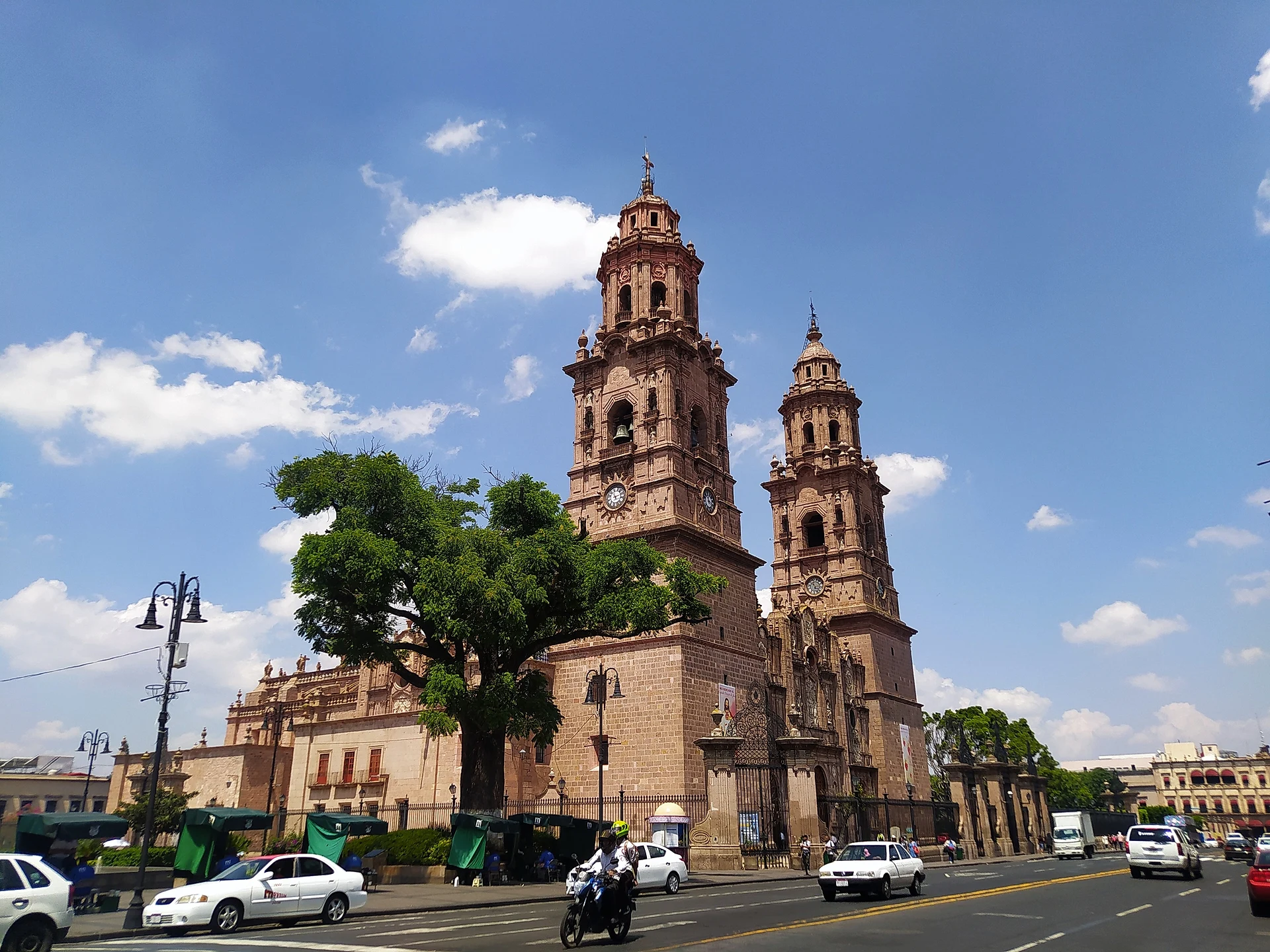 Morelia's pink-stone cathedral towers above Avenida Madero on a sunny day, Michoacán