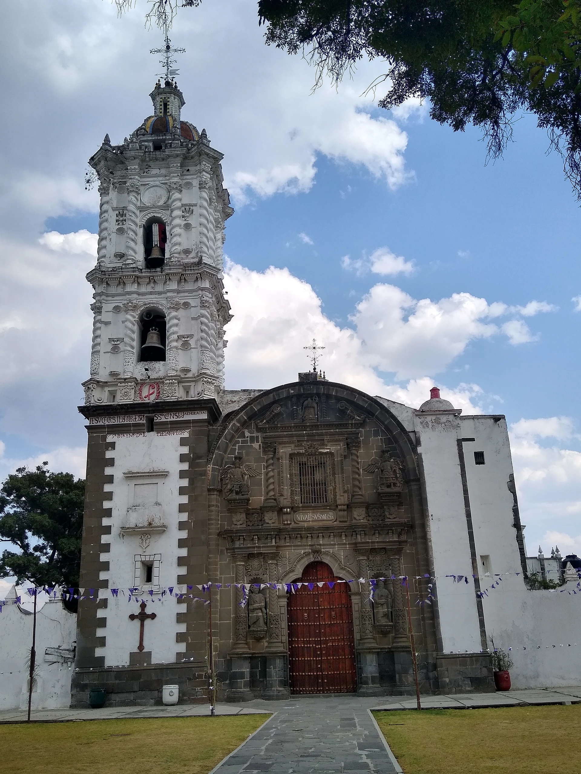 Fachada de cantera gris y torre de argamasa de la parroquia de San Dionisio en Yauhquemehcan, Tlaxcala