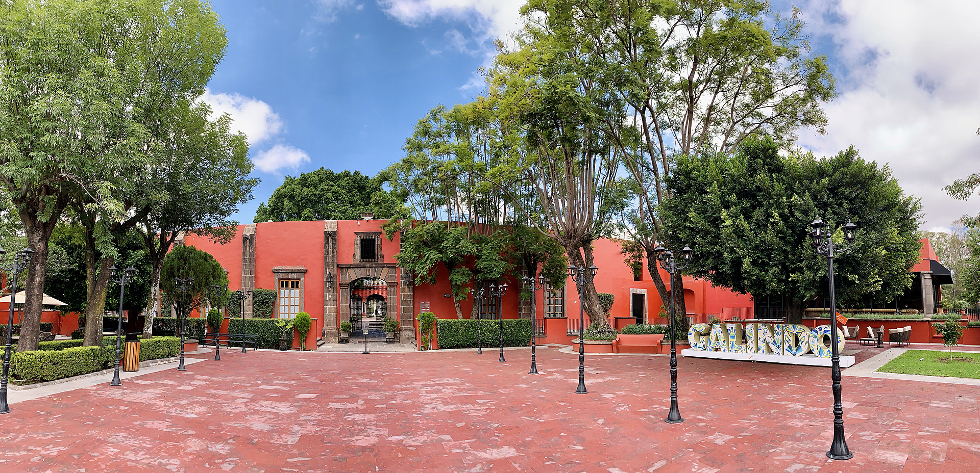 Red buildings and gardens around the courtyard of Hacienda Galindo, Querétaro