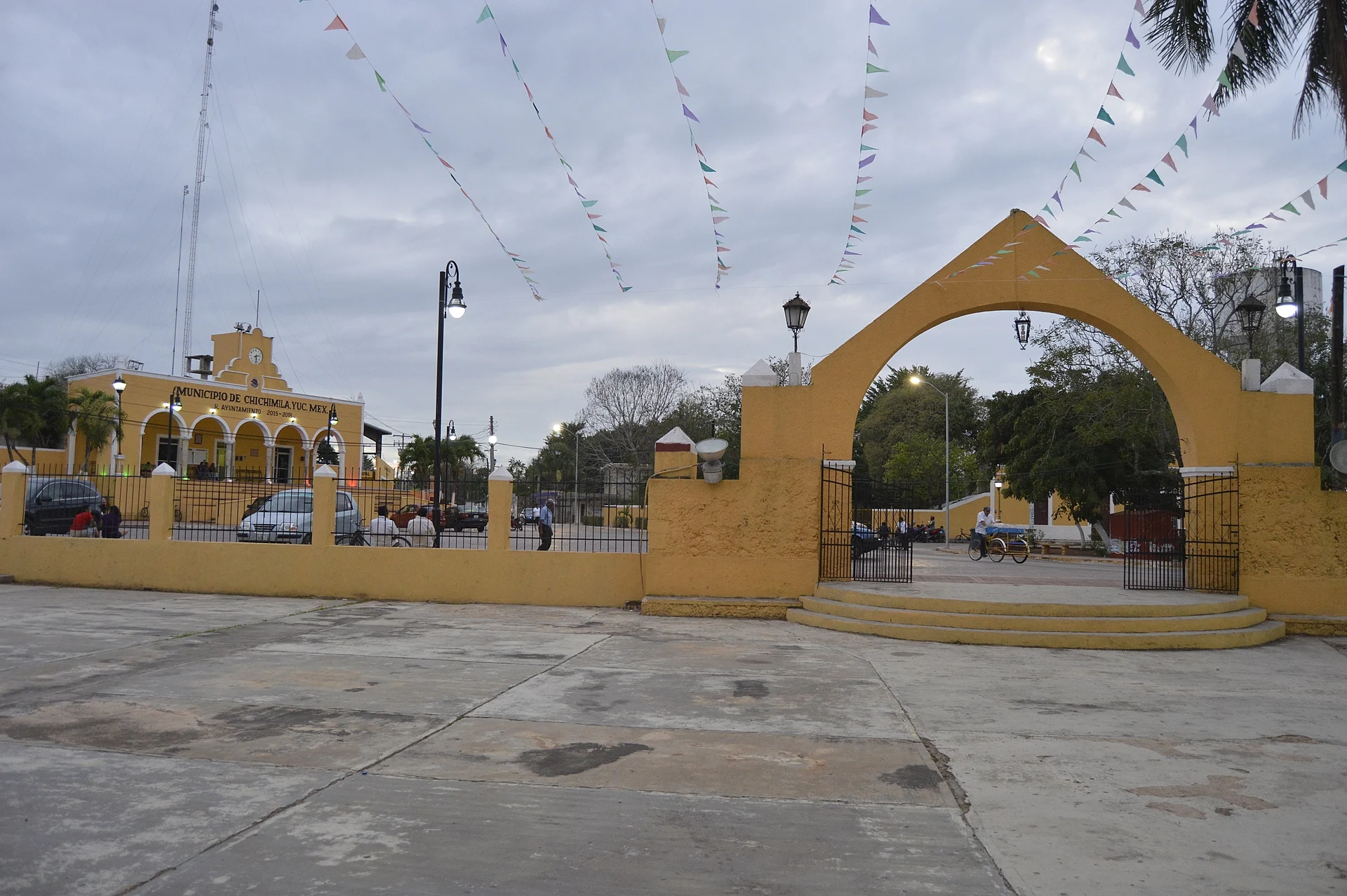 The main plaza of Chichimilá with its masonry arch and yellow buildings behind, Yucatán