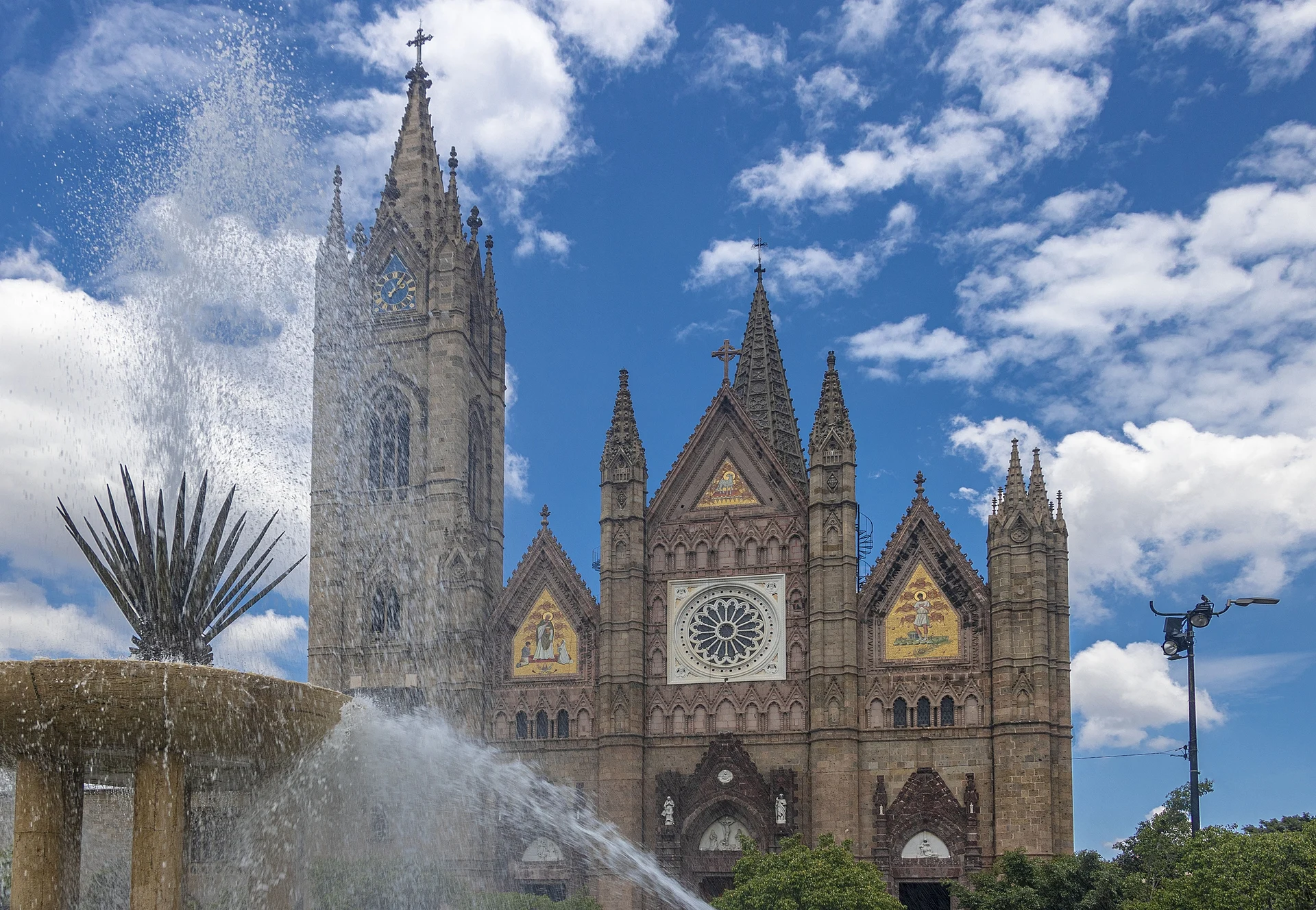 La fachada neogótica del Templo Expiatorio, en la colonia Americana de Guadalajara, con una fuente en primer plano, Jalisco