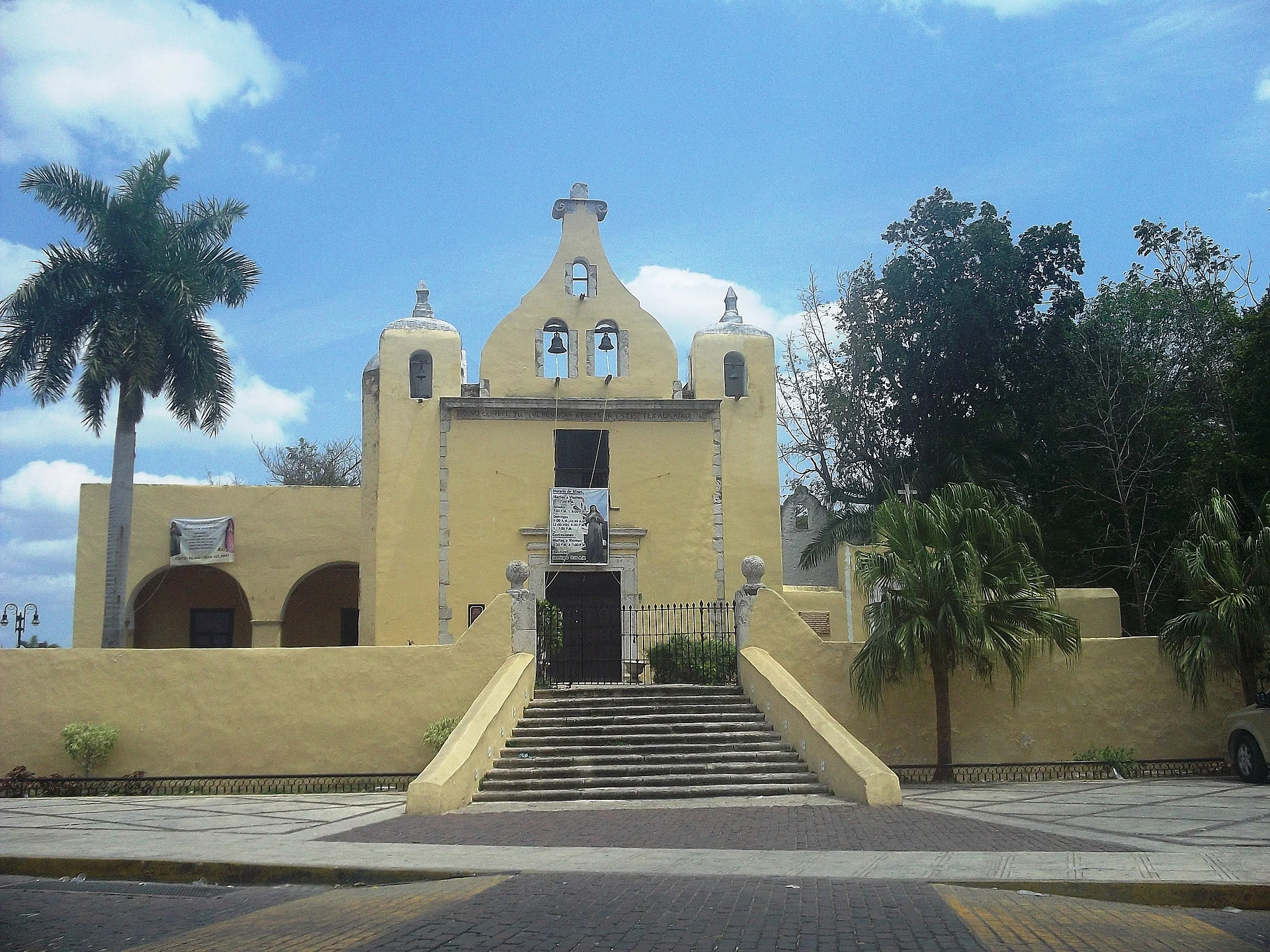 La fachada amarilla y la espadaña escalonada de la Ermita de Santa Isabel sobre su escalinata, Yucatán