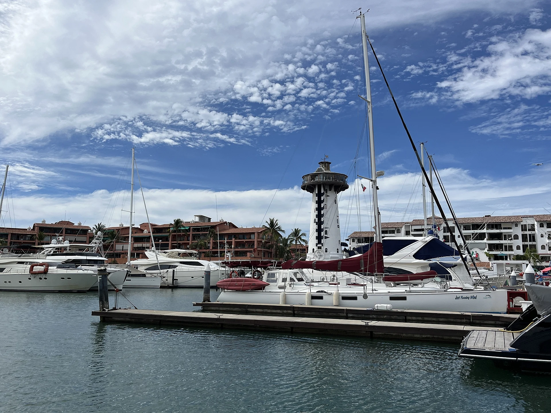 Yates amarrados en Marina Vallarta con la torre del faro al fondo, Jalisco